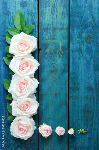 Fototapeta Naklejka Na Ścianę i Meble -  Wedding border with light pink rose flowers on blue wooden background