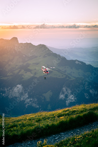 Hubschrauber, der über Landschaft gegen den Himmel in den Sonnenuntergang fliegt