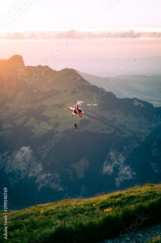 Hubschrauber, der über Landschaft gegen den Himmel in den Sonnenuntergang fliegt