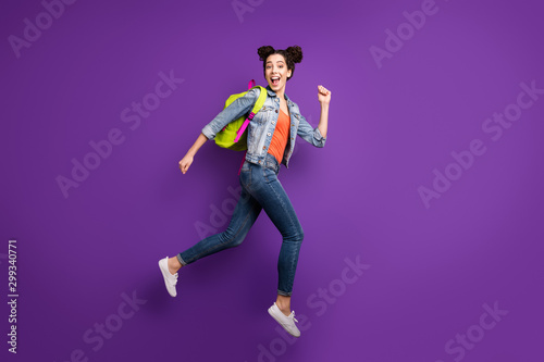 Shopping time. Full size profile photo of funny student lady jumping high glad to finish study rushing mall wear green bag casual denim outfit isolated purple color background