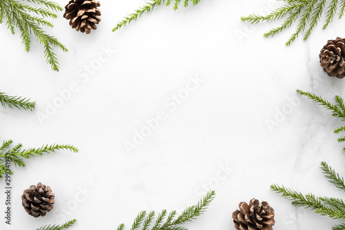 Obraz na płótnie White marble table with Christmas decoration including pine branches and pine cones