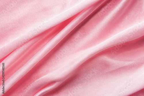 Delicate pink jersey fabric background with swirl creased texture. Sewing fashion clothes making wedding women's apparel concept