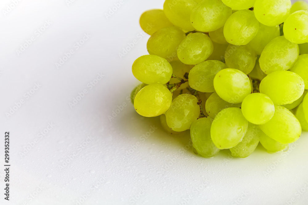 brush of ripe Kishmish grapes with drops of water on a white background close-up brush of ripe Kishmish grapes with drops of water on a white background close-up