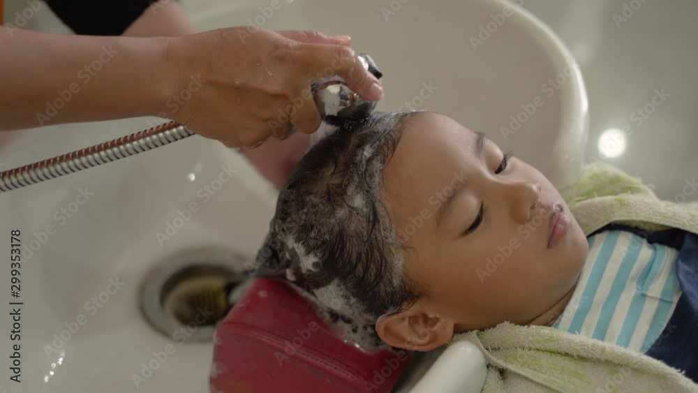 portrait of young child with her hair being washed in salon