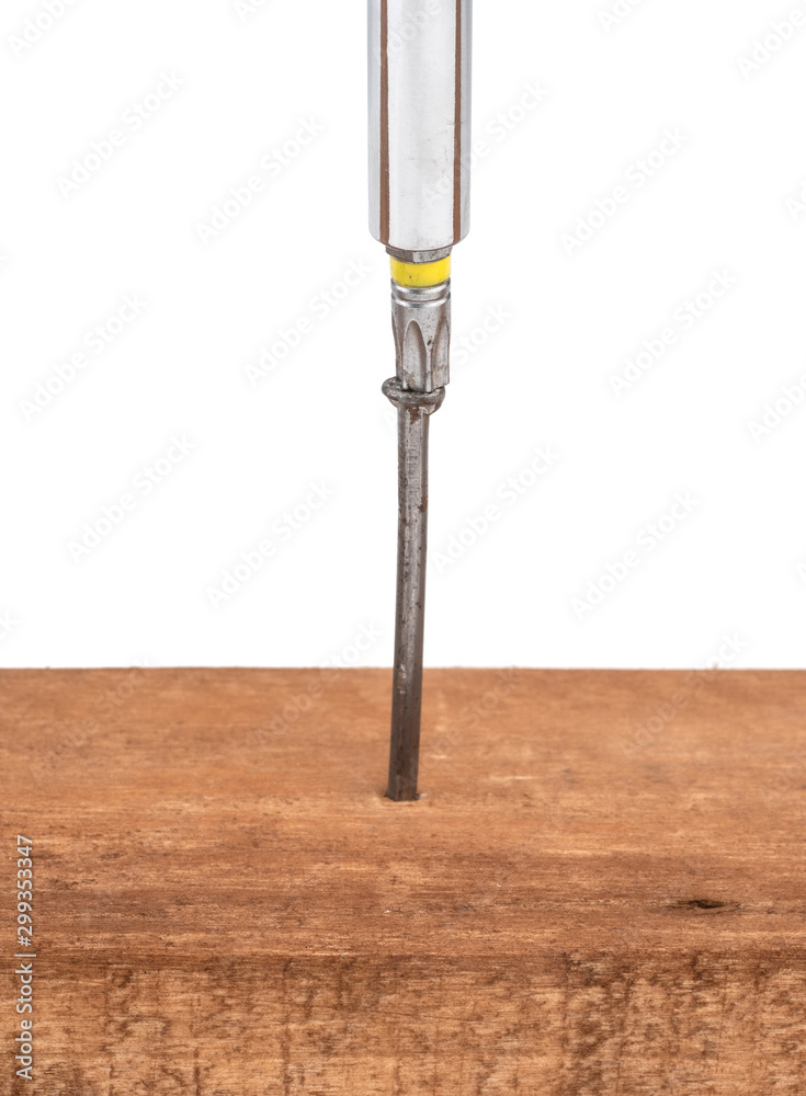 A screwdriver twists a nail into a board. Not the right tool. A screwdriver twists a nail into a board. Not the right tool.