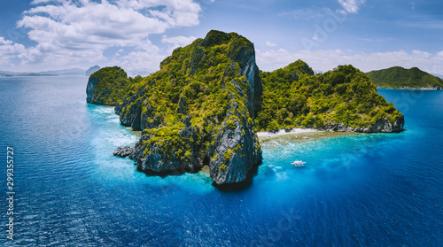 Aerial drone panorama view of tropical paradise island. Karst limestone rocky mountains surrounds by blue ocean and coral reef © Igor Tichonow