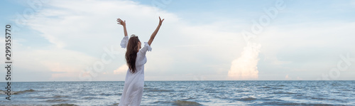 Happy woman raised arms on the beach, summer beach vacation concept.