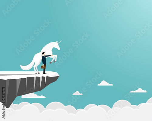 Businessman and unicorn on cliff