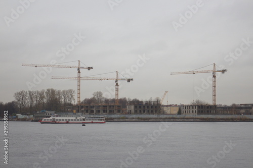 tower cranes on the shore on a cloudy day