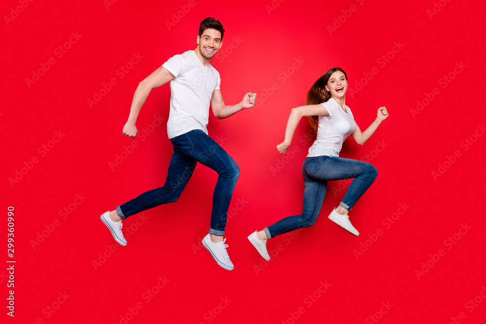 Side profile full length body size photo of cheerful positive nice pretty sweet couple of crazy spouses wear jeans denim white t-shirt smiling in footwear isolated vivid color background run jump