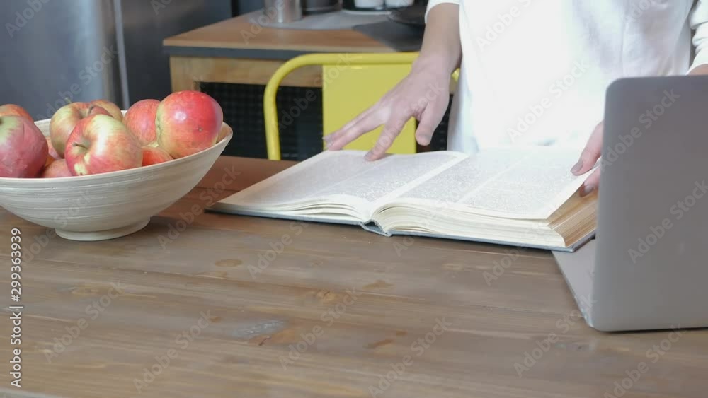 Close-up of hands flipping through cooking book pages