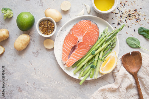 Raw salmon steak with fresh vegetables for garnish.