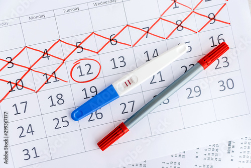 Positive pregnancy test with circling date in calendar. Planning of pregnancy, trying to have baby. photo