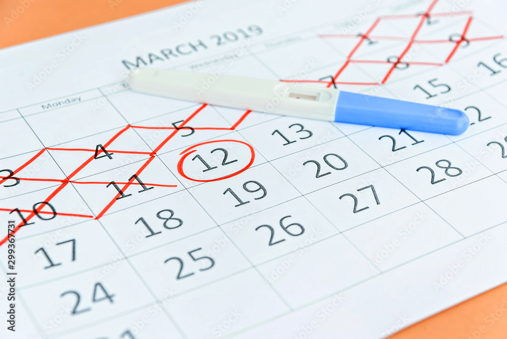 Pregnancy test with circling date in calendar. Planning of pregnancy, trying to have baby. Pregnancy test with circling date in calendar. Planning of pregnancy, trying to have baby.