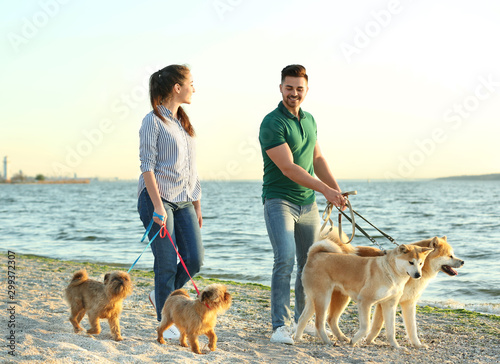 Photography Young couple walking their adorable dogs near river