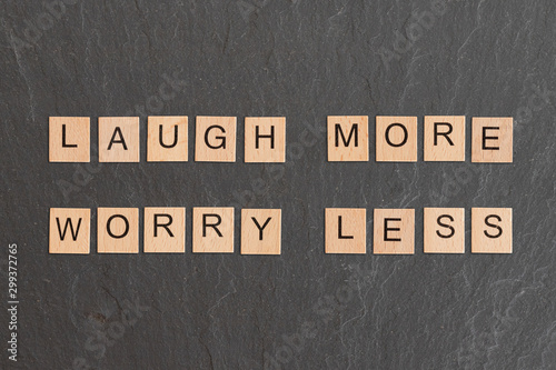 Fototapeta Laugh More Worry Less Written With Game Tiles