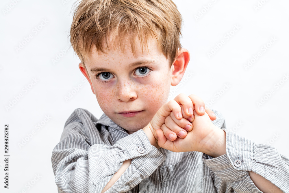 Fotografie smiling child with blue eyes looking determined, holding his fists