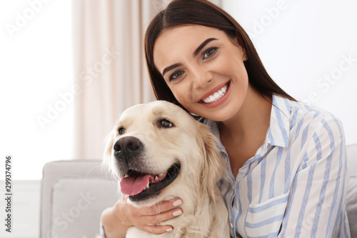 Young woman and her Golden Retriever dog in living room © New Africa