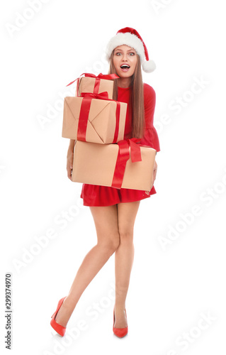 Emotional young woman in Santa hat with Christmas gifts on white background