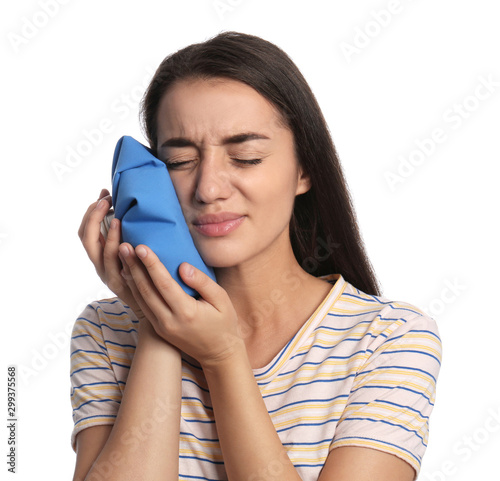 Young woman suffering from toothache on white background photo