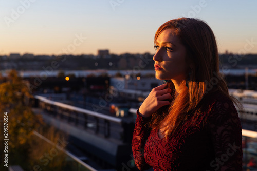 Woman with red hair outside in warm, evening light
