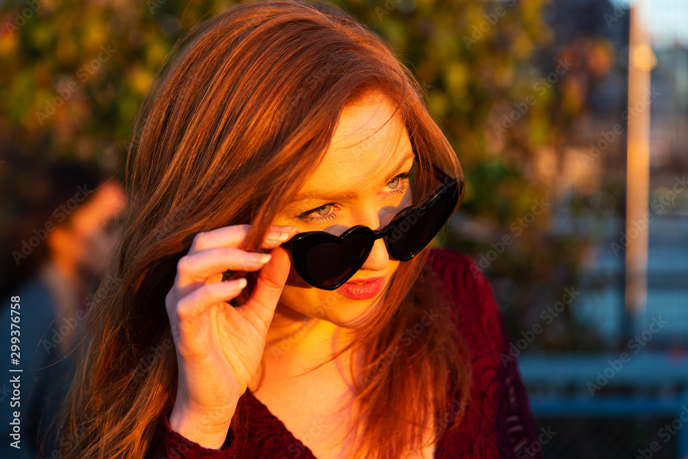 Woman with red hair wearing sunglasses Woman with red hair wearing sunglasses