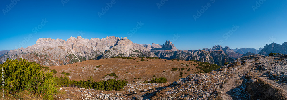 Panoramic view of magical Dolomite peaks at the national park Three Peaks (Tre Cime, Drei Zinnen) in Autumn October colors during sunset at blue sky, South Tyrol, Italy