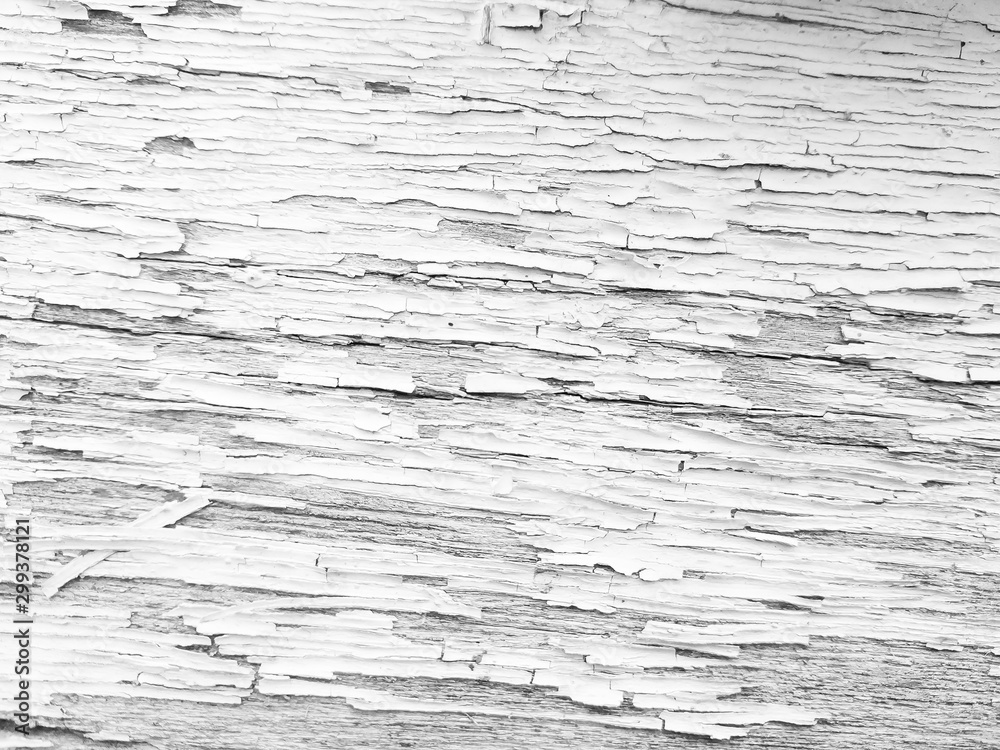 Wood texture with white flaked paint. Peeling paint on weathered wood. Old cracked paint pattern on rusty background. Chapped paint on an old wooden surface
