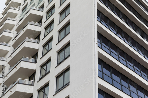 Facade of white parget concrete building surface with windows and balconies