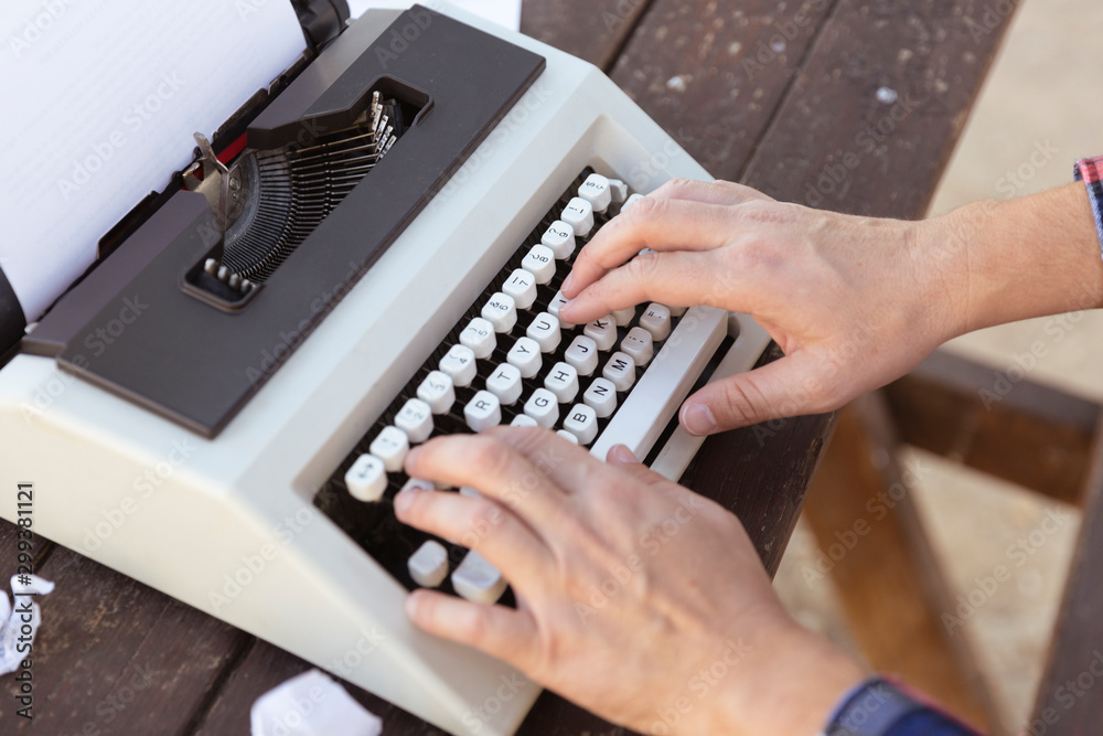 Manos de persona tecleando en maquina de escribir vintage en mesa de  madera. Stock Photo