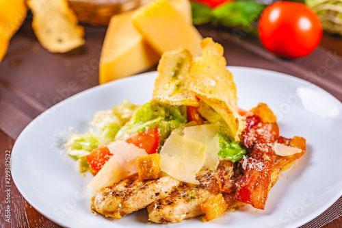 Caesar salad with bacon and chicken on white plate
