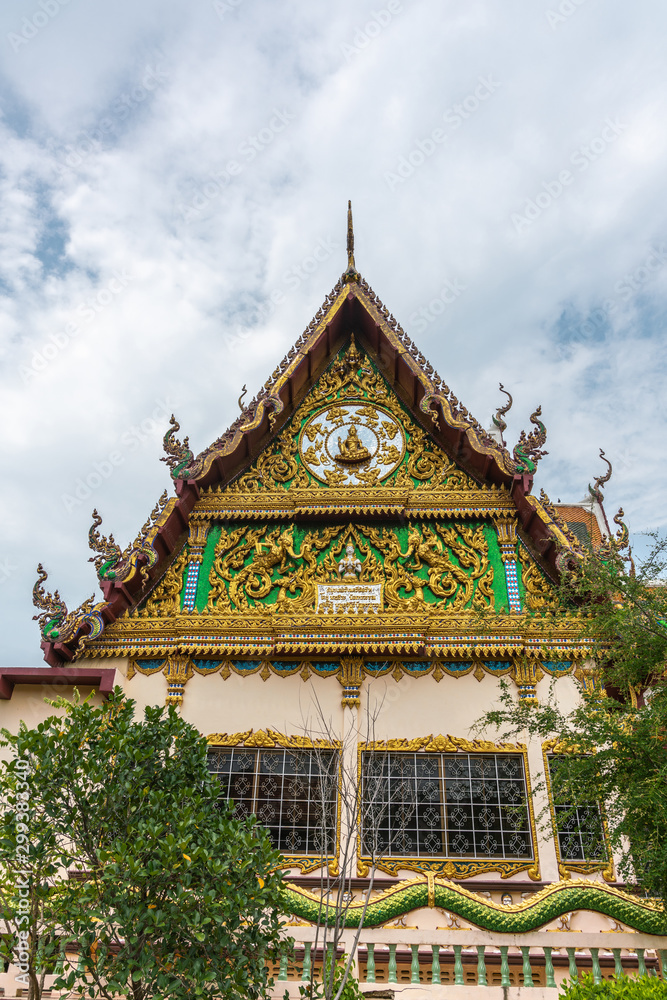 Fototapeta premium Ko Samui Island, Thailand - March 18, 2019: Wat Laem Suwannaram Chinese Buddhist Temple. Elaborately decorated full of colors south side facade under blue cloudscape and green foliage.