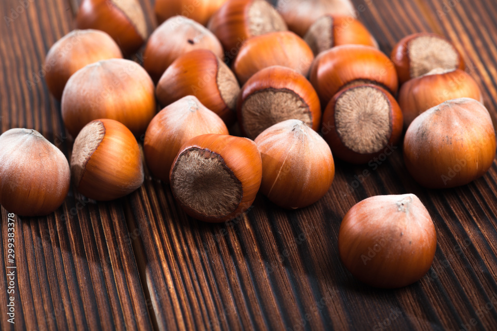 close up of hazelnuts on wooden table . close up of hazelnuts on wooden table .