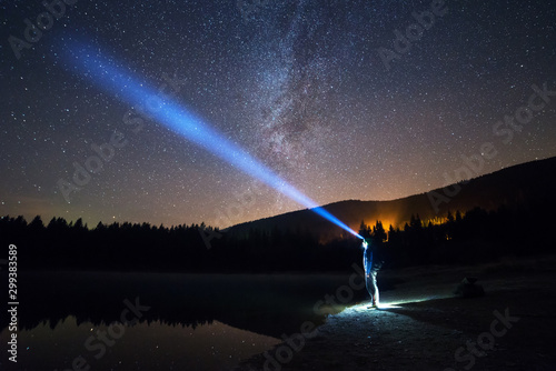 Man Standing Under The Starry Night Sky, Lighting With Head Lamp