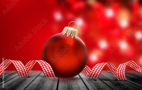 Glänzend Rote Weihnachtskugel mit Weihanchtsdekoration vor Rotem Hintergrund