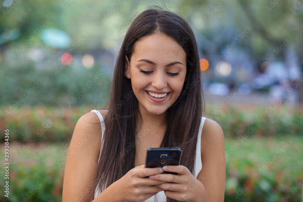Woman wearing white shirt texting on phone over urban background Woman wearing white shirt texting on phone over urban background