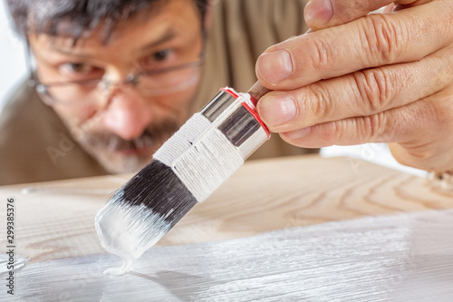 Applying white primer paint on wood