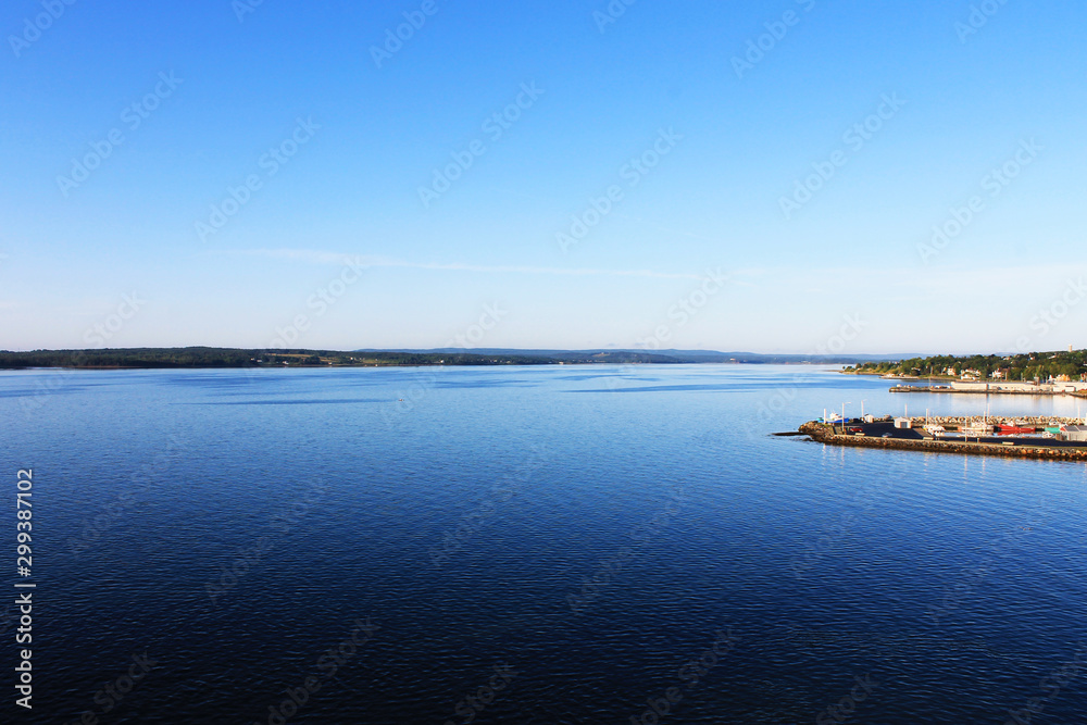 Panoramic view of harbor at North Sydney, Nova Scotia. Clear blue sky, calm water.