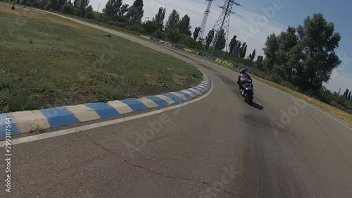 motorcyclist quickly catches up trainee before the race ring track, circle of white, blue biker.