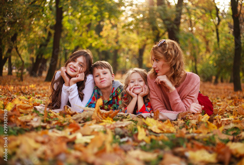 Portrait of happy family in forest park in autumn colorful landscape, motherhood and carefree childhood in nature outdoors