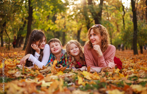 Portrait of happy family in forest park in autumn colorful landscape, motherhood and carefree childhood in nature outdoors