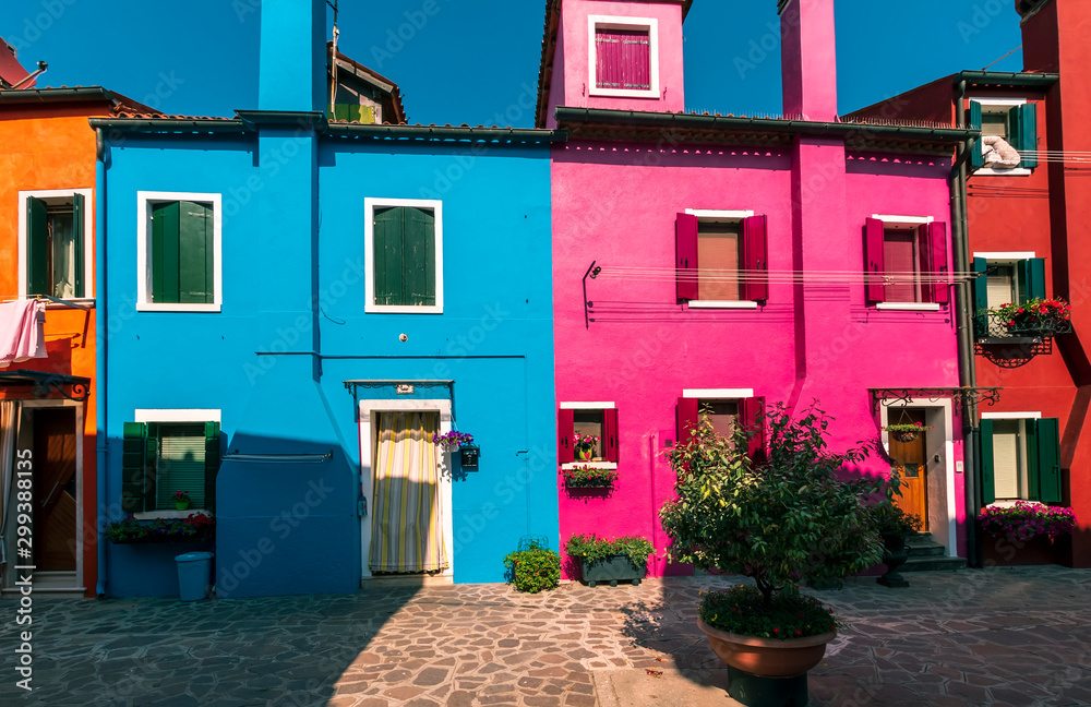 picturesque buildings at a little street , houses of Burano with shadows in the evening