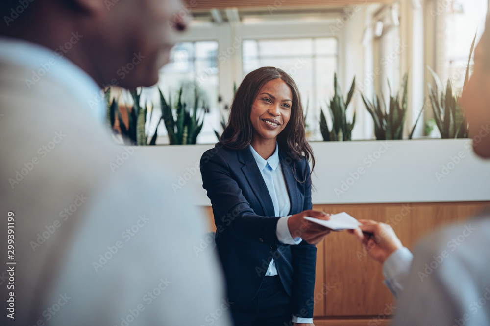 © Flamingo Images - Young African American concierge talking with guests during chec