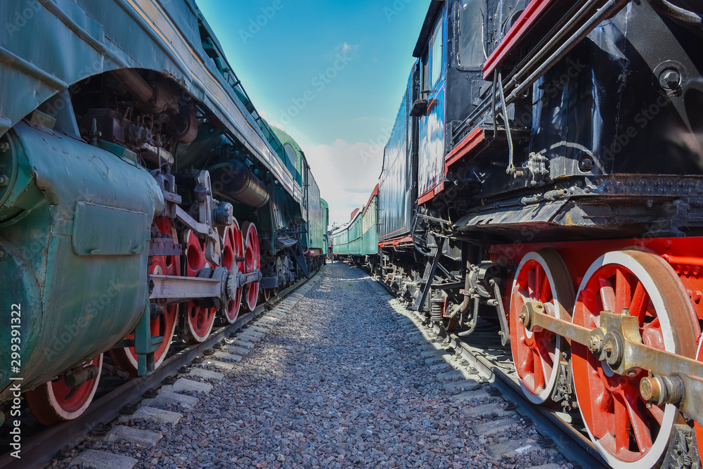 between wagons of old trains, between two old trains, red metal train wheels