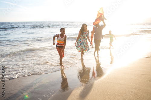 happy family on the beach walking at sunset