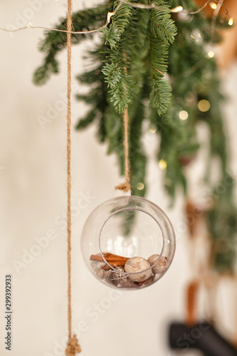 Christmas decorations. Transparent ball on the Christmas tree, a garland of spruce branches. Craft decor in the cozy style