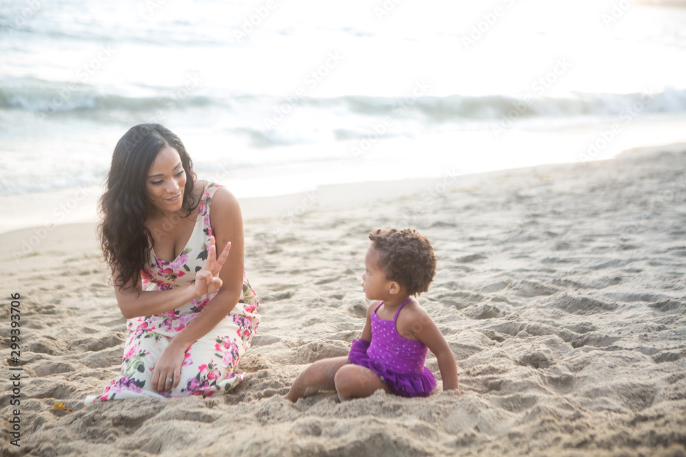 Cute little girl on the beach with her mom