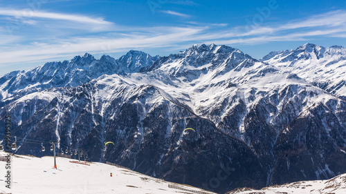 Paragliding over Alps with mountain cliffs covered with snow in Karnten Austria.