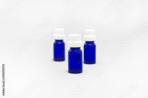 Empty blue glass bottles for essential oils and cosmetic products isolated on white background