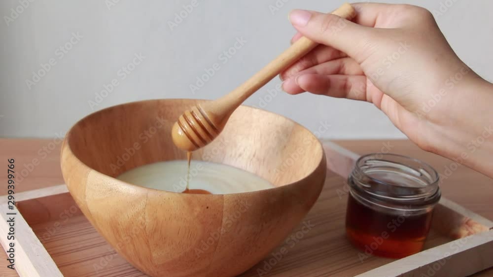 Pouring honey on yogurt. Pouring honey on yogurt.